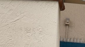 Una mujer entra a una tienda en donde cuelga una lona de color rojo en la que se anuncia contratación.