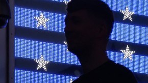 Imagen de una bandera de los Estados Unidos y las siluetas de varias personas.