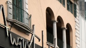 Imagen de un trabajador de FedEx mientras empuja unos paquetes, frente a un camión de la compañía.