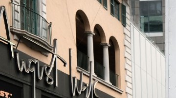 Imagen de un trabajador de FedEx mientras empuja unos paquetes, frente a un camión de la compañía.