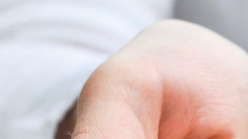 Una persona muestra con su mano unas llaves y con la otra sostiene una casa en miniatura.