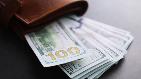 Un fajo de dólares saliendo de una billetera.