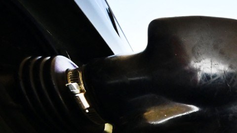 Imagen de una pistola de gasolina que carga en un automóvil.