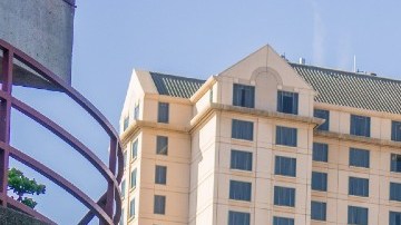 Imagen del centro de San José, en California, con edificios al fondo, personas caminando y árboles.