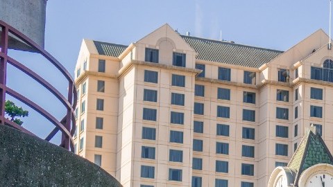 Imagen del centro de San José, en California, con edificios al fondo, personas caminando y árboles.