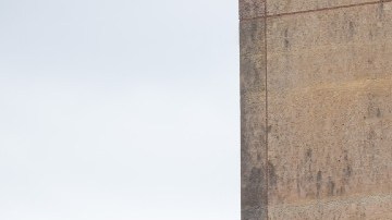 Un muro de color café en el que se observa un logotipo de la cafetería Starbucks, en color verde y con una bandera de Estados Unidos en el fondo.