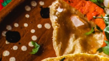 Imagen de varios tacos al pastor, colocados unos sobre otros.