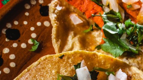 Imagen de varios tacos al pastor, colocados unos sobre otros.