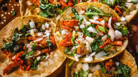 Imagen de varios tacos al pastor, colocados unos sobre otros.