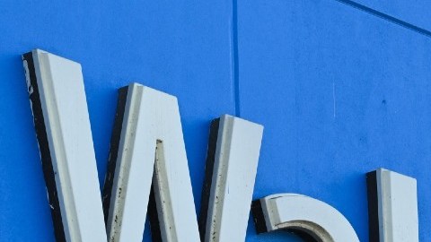 Imagen de una marquesina de Walmart en un muro de color azul.