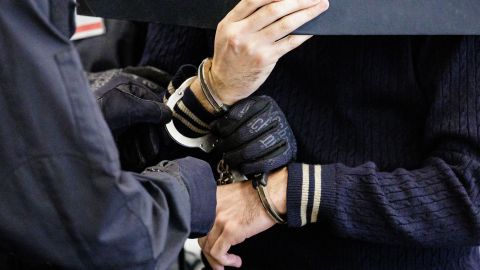 Defendant Wissam R (R) is led in handcuffs into the courtroom of the Higher Regional Court in Dresden, eastern Germany on August 30, 2022 prior to a hearing in the trial over a jewellery heist on the Green Vault (Gruenes Gewoelbe) museum in Dresden's Royal Palace in November 2019. - Six members of a notorious criminal gang stand trial in Germany over the spectacular heist in which 18th-century jewels were snatched from the state museum in Dresden. They are accused of gang robbery and arson after the brazen night raid on The Green Vault museum on November 25, 2019. (Photo by JENS SCHLUETER / POOL / AFP) (Photo by JENS SCHLUETER/POOL/AFP via Getty Images)