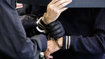 Defendant Wissam R (R) is led in handcuffs into the courtroom of the Higher Regional Court in Dresden, eastern Germany on August 30, 2022 prior to a hearing in the trial over a jewellery heist on the Green Vault (Gruenes Gewoelbe) museum in Dresden's Royal Palace in November 2019. - Six members of a notorious criminal gang stand trial in Germany over the spectacular heist in which 18th-century jewels were snatched from the state museum in Dresden. They are accused of gang robbery and arson after the brazen night raid on The Green Vault museum on November 25, 2019. (Photo by JENS SCHLUETER / POOL / AFP) (Photo by JENS SCHLUETER/POOL/AFP via Getty Images)