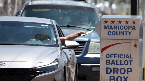 Un votante coloca una boleta en un buzón fuera del Departamento de Elecciones del condado de Maricopa, en Phoenix.