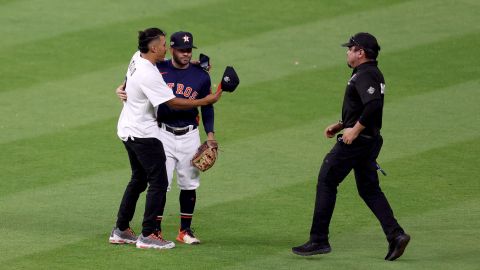 El venezolano José Altuve junto a un fanático que se lanzó al terreno de juego durante el segundo partido de la serie ante los Yankees de Nueva York.