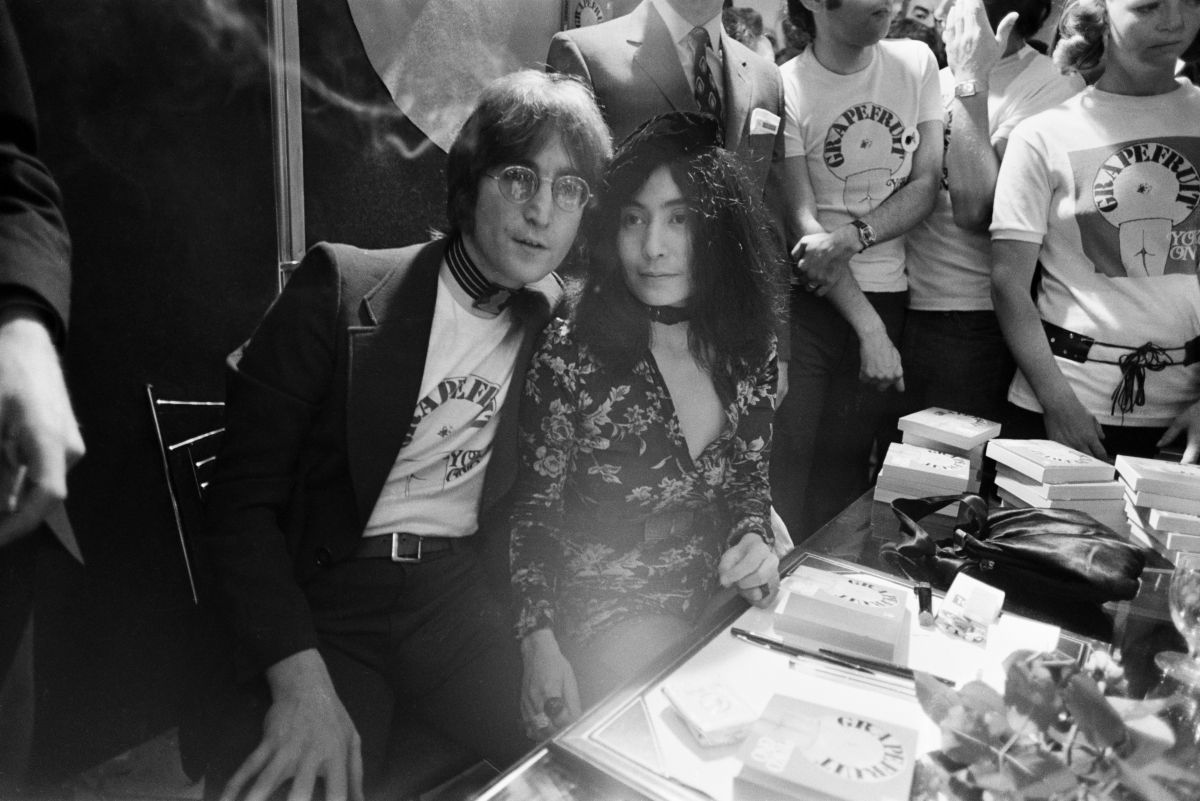 El cantante y compositor John Lennon (1940 - 1980) con su esposa Yoko Ono, firmando ejemplares de su libro de arte conceptual 'Grapefruit' en Selfridges, Londres, 15 de julio de 1971.