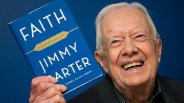 El expresidente Jimmy Carter muestra su libro 'Faith: A Journey For All' el 26 de marzo de 2018