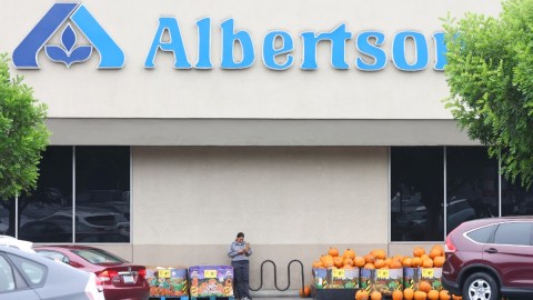 Imagen de una tienda Albertsons con un estante de calabazas de Halloween en medio de un estacionamiento.