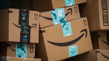 Imagen de varias cajas de cartón apiladas unas sobre otras con logotipos de Amazon.