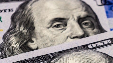 Imagen de billetes de $100 dólares y de cheques del seguro social.
