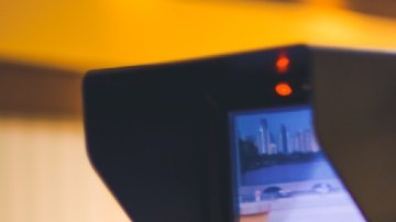 Imagen de una cámara de tv en un foro que se ve al fondo fuera de foco.