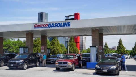 Imagen de varias bombas de gasolina en una estación de Costco en la que se ven varios autos.