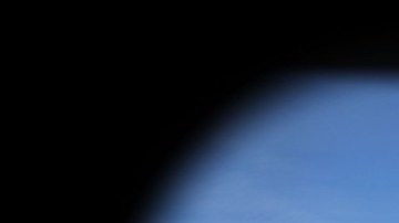 Imagen de un ferrocarril de color amarillo visto desde una ventana y a una persona que camina por las vías.