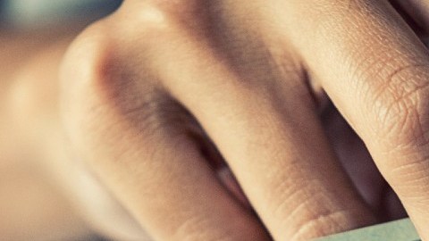 Imagen de unas manos que cuentan billetes de dólar.