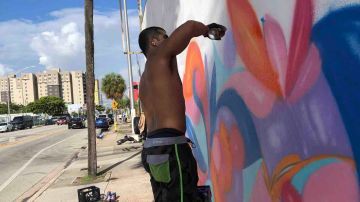 El artista estadounidense Alexander Mijares pinta parte de la obra, en colaboración con Lingoda, para conmemorar el Mes de la Herencia Hispana en Miami (Florida).