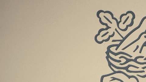 Imagen del logotipo de Nestle y las sombras de unos arbustos.