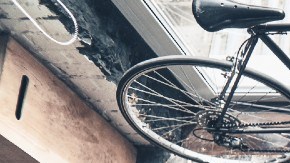 Imagen de cinco personas que rodean una mesa de trabajo con uno de los brazos extendidos hacia el centro.