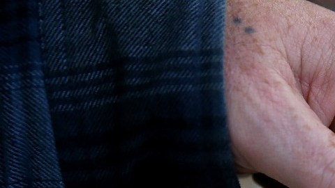 Una mano sostiene varios boletos del sorteo de lotería Powerball.