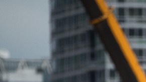 Imagen de una persona que trabaja subida en un andamio, en una obra en construcción.