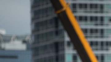 Imagen de una persona que trabaja subida en un andamio, en una obra en construcción.