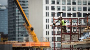 Imagen de una persona que trabaja subida en un andamio, en una obra en construcción.