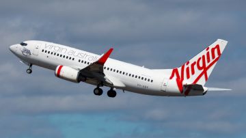Imagen de un avión de color blanco y con letras de color rojo de la aerolínea Virgin Australia.