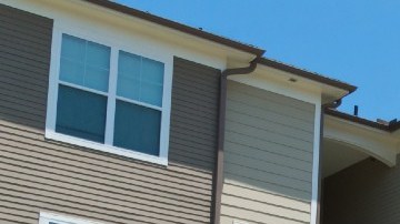 Imagen de una serie de apartamentos en una calle con jardines de pasto.