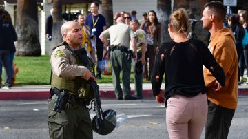 An armed Los Angeles Couty Sheriff's Department officer speaks with parents while securing the premises, after a shooting at Saugus High School in Santa Clarita, California on November 14, 2019. - A teenager shot dead two fellow students and wounded three others on his sixteenth birthday at a high school north of Los Angeles, before turning the gun on himself and being taken into custody still alive. (Photo by Frederic J. BROWN / AFP) (Photo by FREDERIC J. BROWN/AFP via Getty Images)