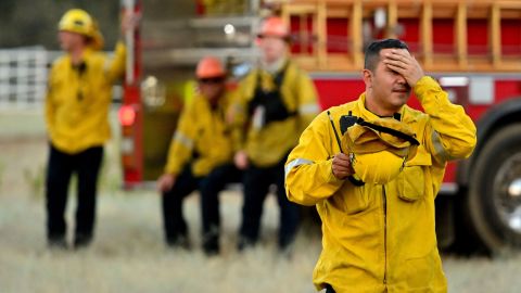 Firefighters wait in an open field as flames make their way across a hillside during the Apple fire near Banning, California on August 1, 2020. - 4,125 acres have burn in Cherry Valley, about 2,000 people have received evacuation orders in the afternoon of August 1,2020, and round 8pm PT the fire spread to 12,000 acres. (Photo by JOSH EDELSON / AFP) (Photo by JOSH EDELSON/AFP via Getty Images)