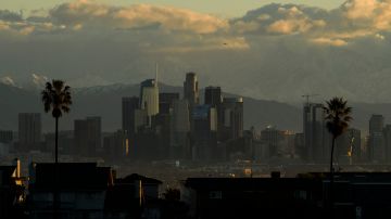 Snow-topped mountains stand behind the Los Angeles downtown skyline after sunrise following heavy rains as seen from the Kenneth Hahn State Recreation Area on December 29, 2020 in Los Angeles, California. (Photo by Patrick T. Fallon / AFP) (Photo by PATRICK T. FALLON/AFP via Getty Images)