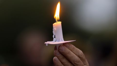 A man holds a candle during a candlelight vigil for cinematographer Halyna Hutchins, who was accidentally killed by a prop gun fired by actor Alec Baldwin, in Burbank, California on October 24, 2021. - The police investigation into a fatal shooting with a prop gun fired by actor Alec Baldwin on a film set was focusing October 23, 2021 on the specialist in charge of the weapon and the assistant director who handed it to Baldwin. Ukraine-born cinematographer Halyna Hutchins, 42, was struck in the chest and died shortly after the incident Thursday in New Mexico, while director Joel Souza, 48, who was crouching behind her as they lined up a shot, was wounded and hospitalized, then released (Photo by DAVID MCNEW / AFP) (Photo by DAVID MCNEW/AFP via Getty Images)