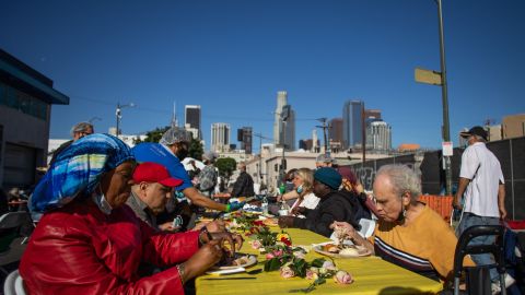 Homeless people eat the Thanksgiving meal served by the nonprofit Midnight Mission to nearly 2,000 homeless people in the Skid Row neighborhood of downtown Los Angeles on November 25, 2021. (Photo by Apu GOMES / AFP) (Photo by APU GOMES/AFP via Getty Images)