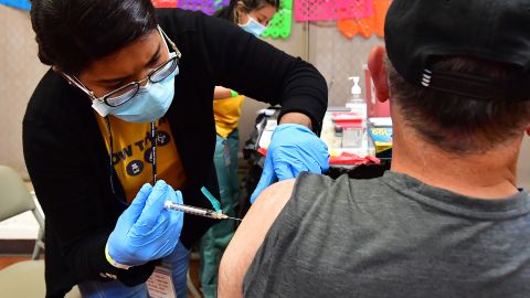 Registered Nurse Mariam Salaam administers the Pfizer booster shot at a Covid vaccination and testing site decorated for Cinco de Mayo at Ted Watkins Park in Los Angeles on May 5, 2022. - Covid cases in Los Angeles County have topped 3,000 for the first time since mid-February with cases up nearly 300 percent in the past month, sparking concern of a potential "sixth wave" pandemic in the US. (Photo by Frederic J. BROWN / AFP) (Photo by FREDERIC J. BROWN/AFP via Getty Images)