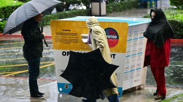 People drop off their ballots for the 2022 Midterm Elections in the rain at a ballot box outside the Los Angeles County Registrar in Norwalk, California on November 8, 2022. (Photo by Frederic J. BROWN / AFP) (Photo by FREDERIC J. BROWN/AFP via Getty Images)