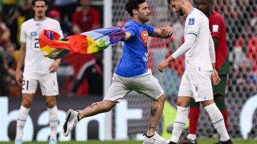 Aficionado corriendo en el Portugal vs. Uruguay con la bandera LGBTQ+ en Qatar 2022.