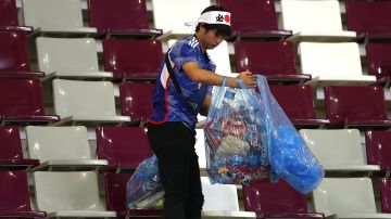 Aficionado de la Selección de Japón ayuda a limpiar estadio en el Mundial de Qatar 2022.