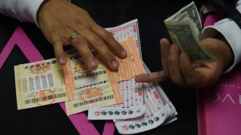 A customer picks up her California Powerball lottery tickets at the famous Bluebird Liquor store which is considered to be a lucky retailer of tickets, in Hawthorne, California on January 13, 2016. Record sales drove up the largest jackpot in US history to a whopping $1.5 billion as people dreaming of riches flocked across state lines and international borders to buy tickets. / AFP / MARK RALSTON (Photo credit should read MARK RALSTON/AFP via Getty Images)