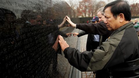 El ex infante de marina de los Estados Unidos Frank Corcoran, miembro de Veterans for Peace, y Ho Sy Hai, un veterano del Ejército de Vietnam del Norte, buscan nombres mientras recorren el Muro Conmemorativo de la Guerra de Vietnam durante un Evento que reúne a las víctimas del uso del Agente Naranja, un defoliante ampliamente utilizado por el ejército estadounidense en la guerra de Vietnam el 28 de noviembre de 2005 en Washington, DC.