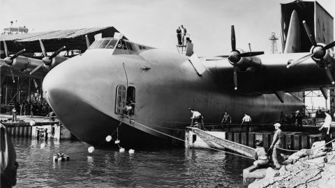 El aviador estadounidense Howard Hughes (con sombrero) sobre su hidroavión Spruce Goose (un Hughes H-4 Hercules), dirigiendo las operaciones para el lanzamiento en Long Beach, el 6 de noviembre de 1947.