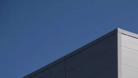 Imagen de la fachada de un edificio de la empresa Amazon con el logotipo en color gris y azul.