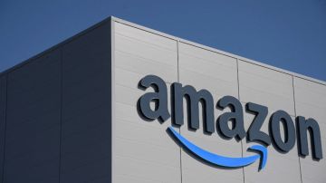 Imagen de la fachada de un edificio de la empresa Amazon con el logotipo en color gris y azul.